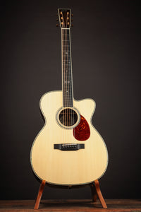 Acoustic guitar on a stand against a dark background
