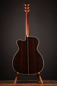 Acoustic guitar on a stand against a dark background