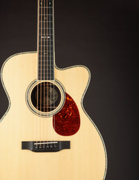 Acoustic guitar with a cutaway on a black background