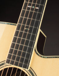 Close-up of an acoustic guitar's fretboard and strings on a dark background