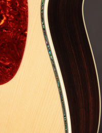 Close-up of a guitar's body with a focus on the wood grain and finish.