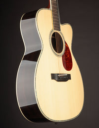 Acoustic guitar with a cutaway on a black background, side view