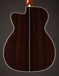 Acoustic guitar with a cutaway on a black background, back view