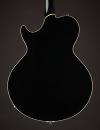 Black electric guitar on a dark background