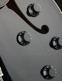 Close-up of a guitar's control knobs on a black background