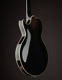Black electric guitar on a dark background