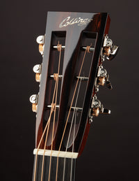 Close-up of a guitar headstock with 'Collings' branding on a dark background
