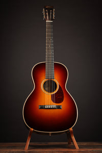 Acoustic guitar on a stand against a dark background