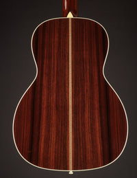 Back view of an acoustic guitar on a dark background