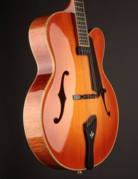 Side view of a sunburst archtop guitar.