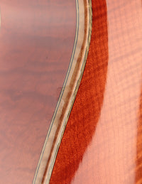 Close-up of a guitar's wooden body with a focus on the grain and finish.