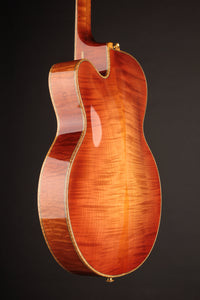Back view of an archtop guitar on a dark background
