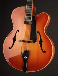 Archtop guitar with a sunburst finish on a black background