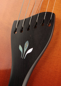 Close-up of a guitar's decorative shell-inlaid tailpiece.