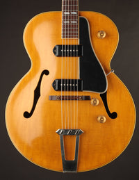 Vintage-style electric guitar with a wooden finish on a dark background