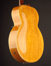 Close-up of a wooden electric guitar on a dark background