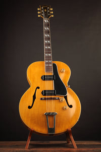 Electric guitar on a stand against a dark background