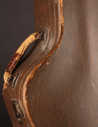 Close-up of a brown leather guitar case with visible wear.