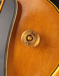 Close-up of a wooden instrument with a gold control knob