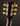 Close-up of a guitar headstock with six tuning pegs on a dark background