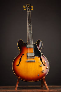 1961 Sunburst Gibson ES-335TD on a stand against a dark background.
