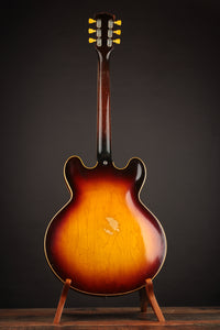 1961 Sunburst Gibson ES-335TD on a stand against a dark background, back view 