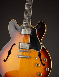 Close-up of a 1961 Sunburst Gibson ES-335TD electric guitar on a black background
