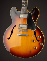 1961 Sunburst Gibson ES-335TD electric guitar against a dark background 