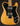 Guitar with a black pickguard and natural wood body on a dark background