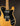 Guitar with a black pickguard and wooden body on a dark background