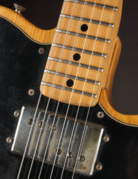 Close-up of a guitar's neck pickup with a  dark background