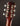 Close-up of a guitar headstock with tuning pegs on a dark background