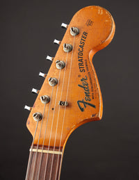 Close-up of a Fender Stratocaster guitar headstock on a dark background
