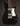 Black electric guitar with a white pickguard on a dark background