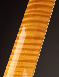Close-up of a guitar neck with a dark background
