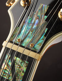 Close-up of a guitar's headstock with abalone inlay