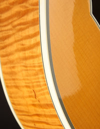 Close-up of a guitar's wooden finish with a focus on the grain and texture.
