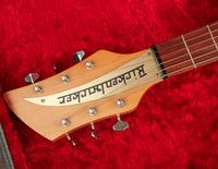 Guitar headstock with tuning pegs on a red background