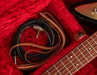 Guitar cable and strap in a red guitar case
