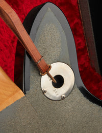 Close up of guitar strap attached to an electric guitar