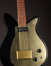 Black and gold electric guitar on a dark background