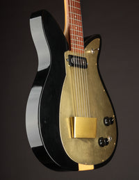 Guitar with black and gold finish on a dark background
