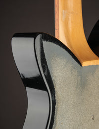 Black and gold electric guitar on a dark background, close up 