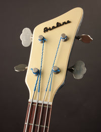Close-up of a bass guitar headstock with 'Airline' branding on a dark background