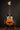 Electric bass guitar with a sunburst finish on a stand against a dark background