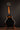 Electric bass guitar on a stand against a dark background