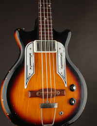 Vintage bass guitar with a sunburst finish on a dark background