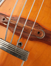 Close up of bridge and tailpiece on a bass guitar
