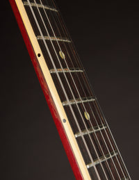 Close-up of a guitar neck against a black background