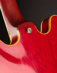Close-up of a red electric guitar on a black background